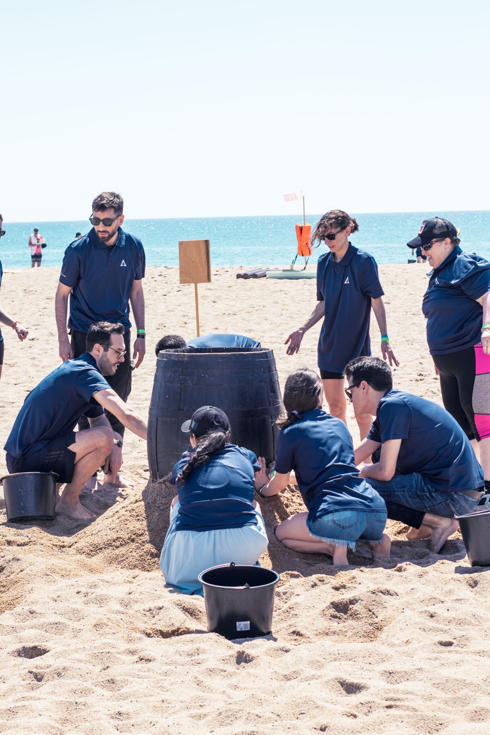Equipo de ID Finance celebrando la victoria tras un team building en la playa de supervivencia