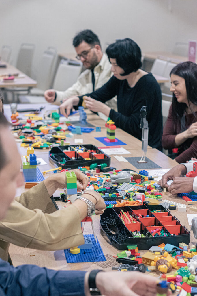 equipo de empleados trabajando en una actividad team building de empresa basada en la metodología lego serious play
