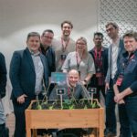 Equipo de más de 100 personas construyendo y plantando jardineras en una actividad de team building RSC en Sevilla