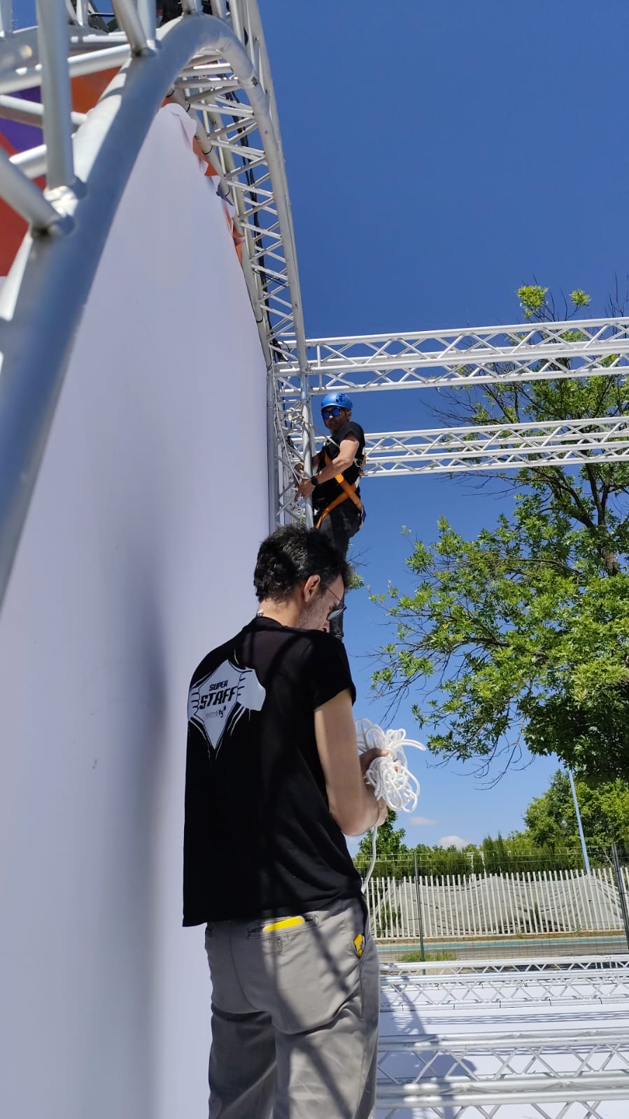 auxiliar de montaje trabajando en truss en festival