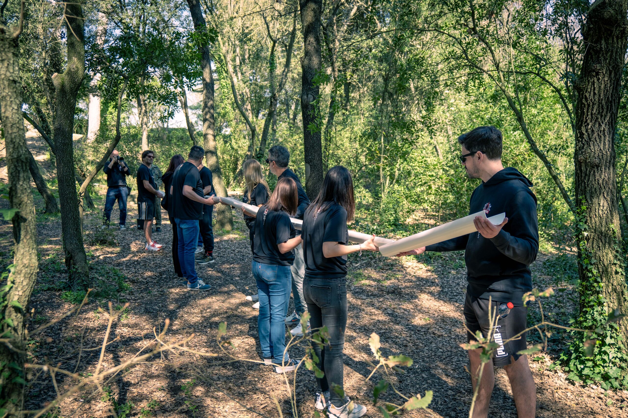 Participantes de empresa colaborando y resolviendo objetivos en el bosque durante un team building táctico