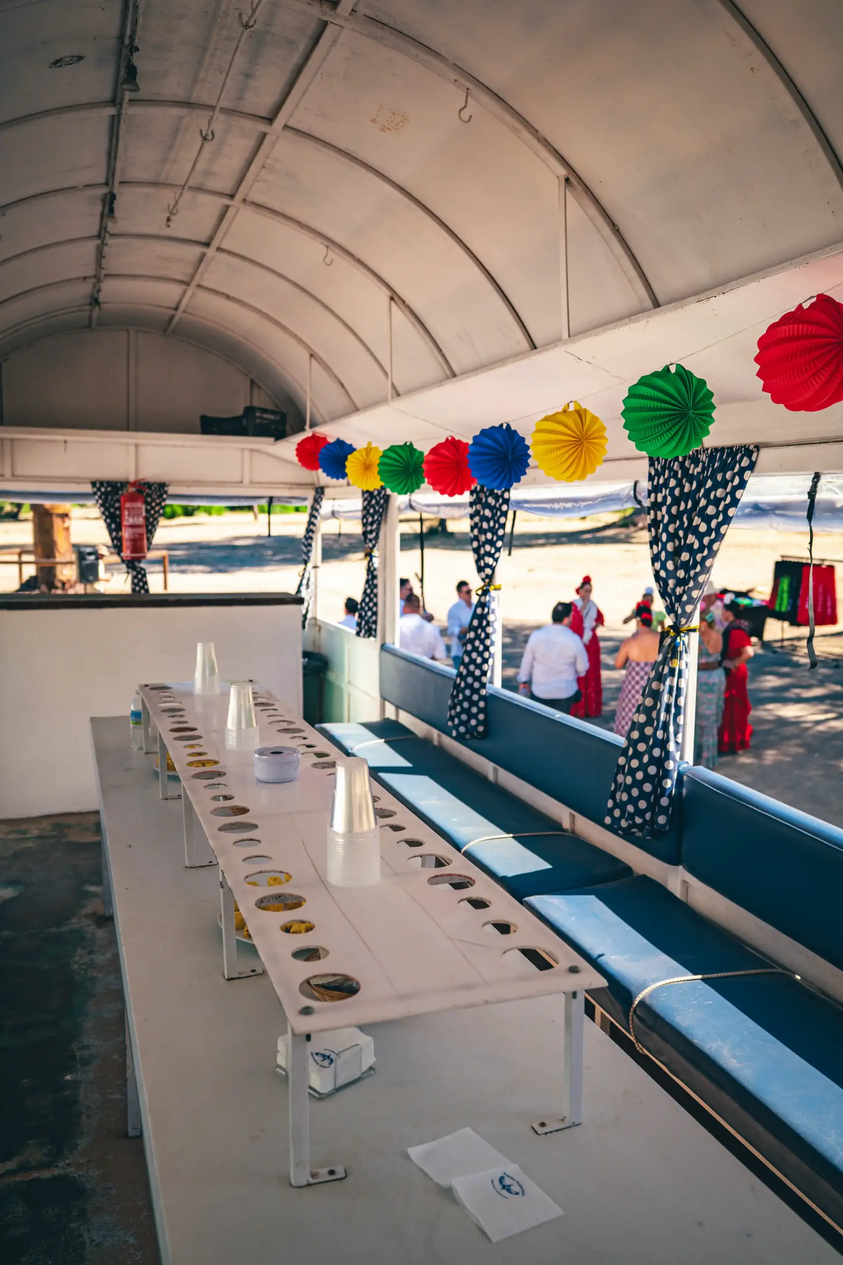 Interior de remolque preparado con barra libre, y de fondo un coro de flamencas preparadas para recibir a los participantes