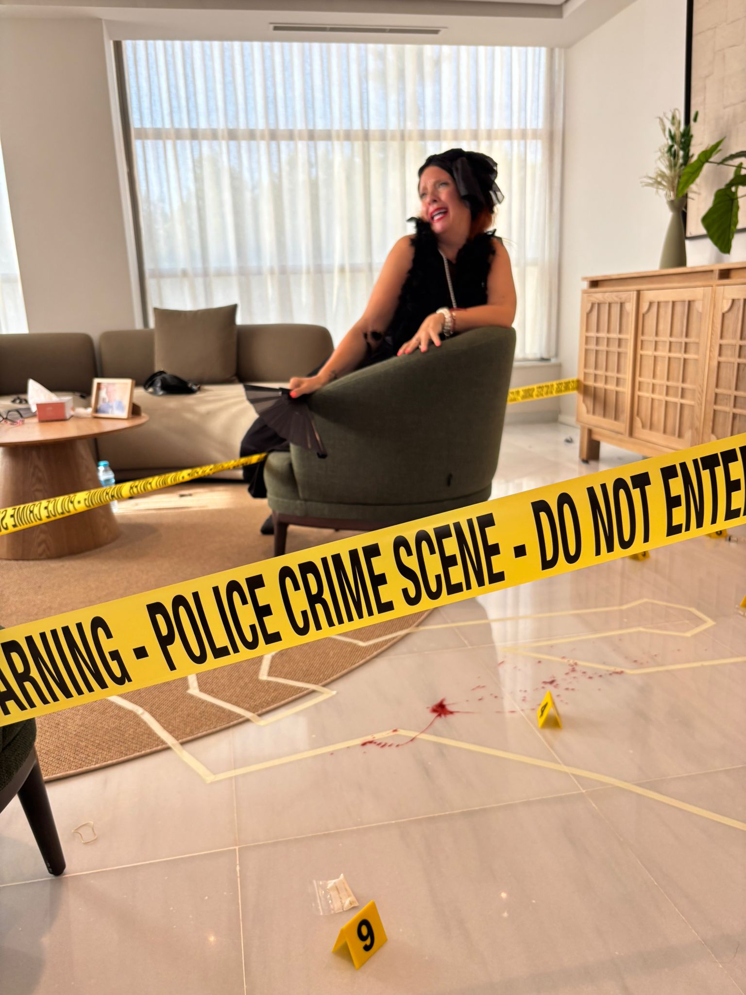 Primer plano de una escena de crimen simulada para una actividad de team building de Cluedo corporativo, con cinta policial y marcadores de evidencia.